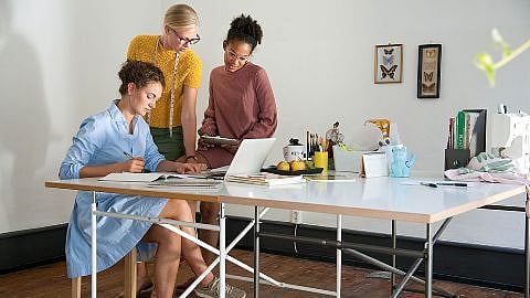 Drei Frauen im Büro am Schreibtisch vor dem Laptop