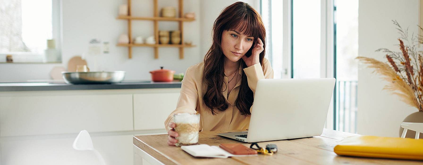 Frau trinkt Kaffee am Computer