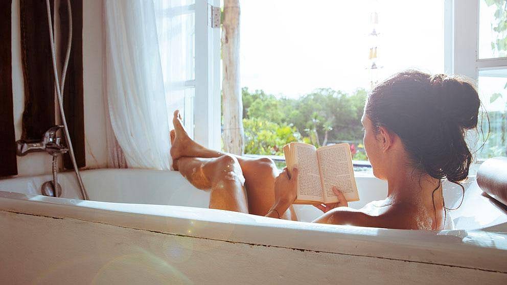 Frau mit Buch in der Badewanne