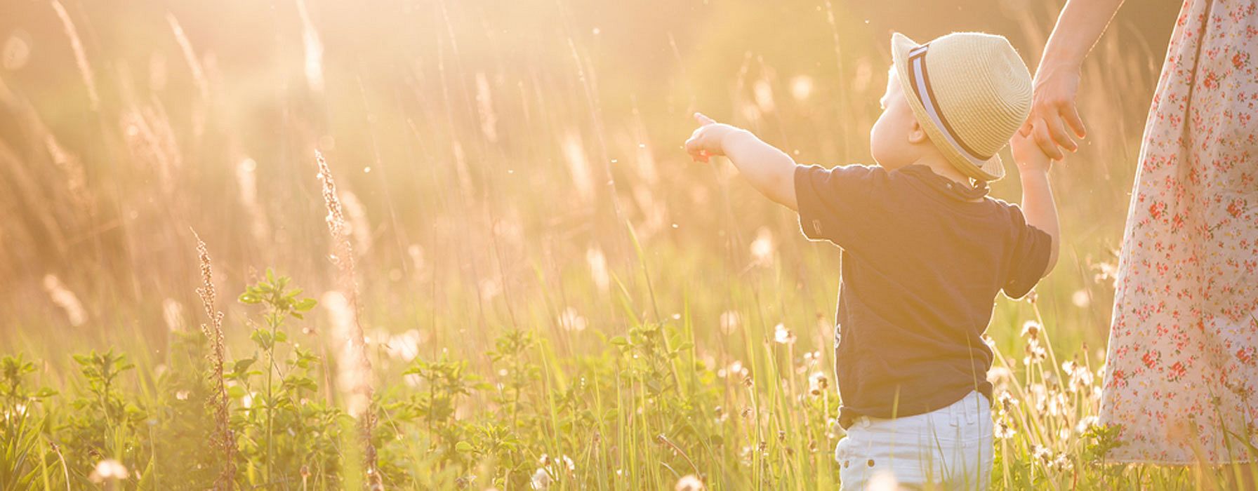 Kind auf der Wiese in der Sonne