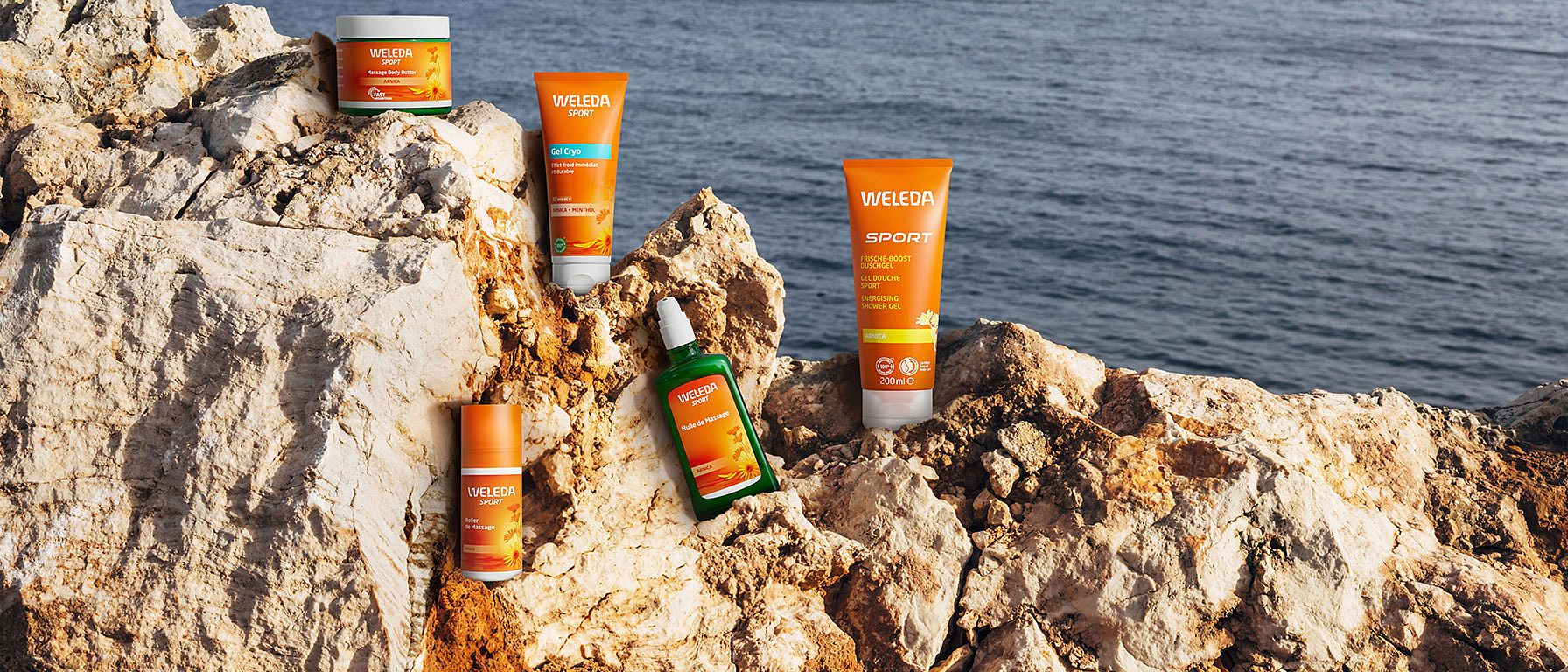 Weleda Arnika Produkte auf einem Felsen am Meer