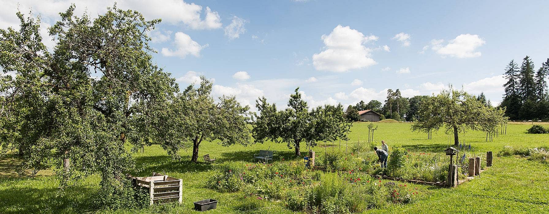 Gaertner in einer weitlaeufigen Gartenlandschaft