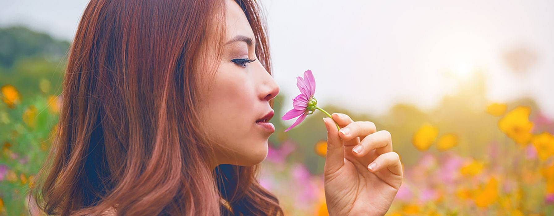 Frau riecht an einer Blume