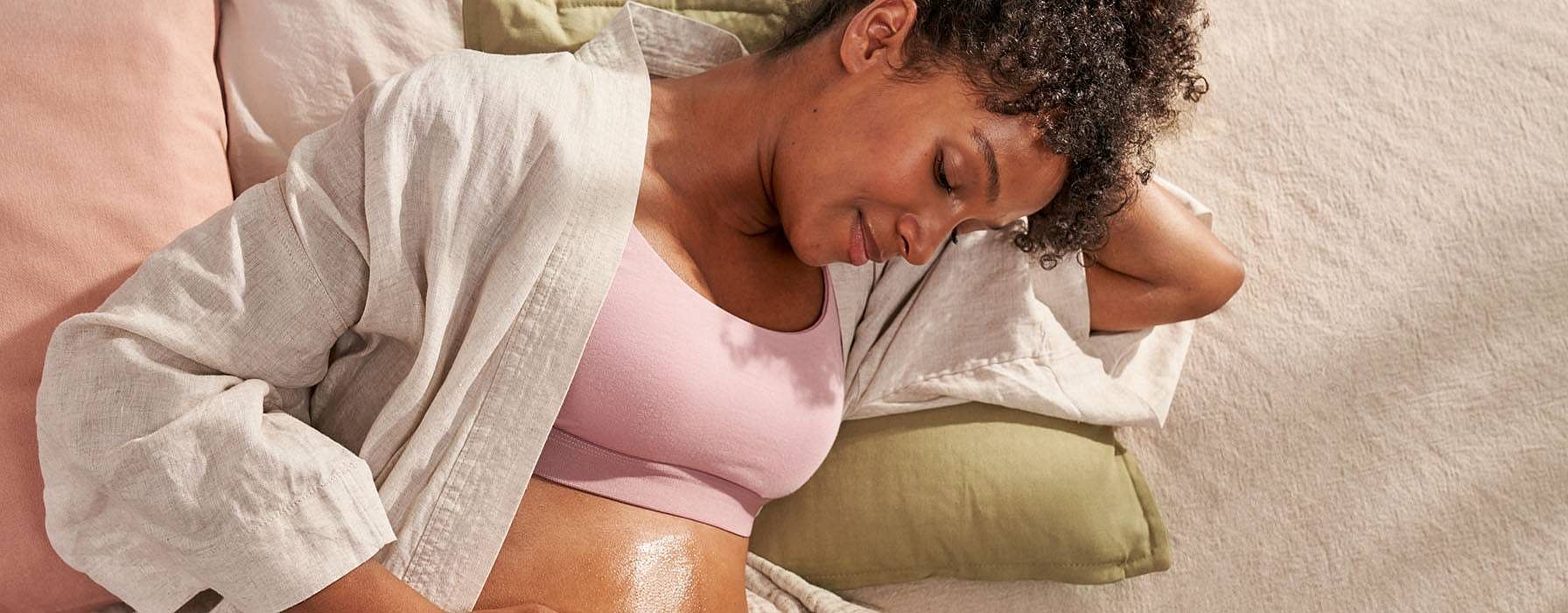 Schwangere Frau massiert sich den Bauch
