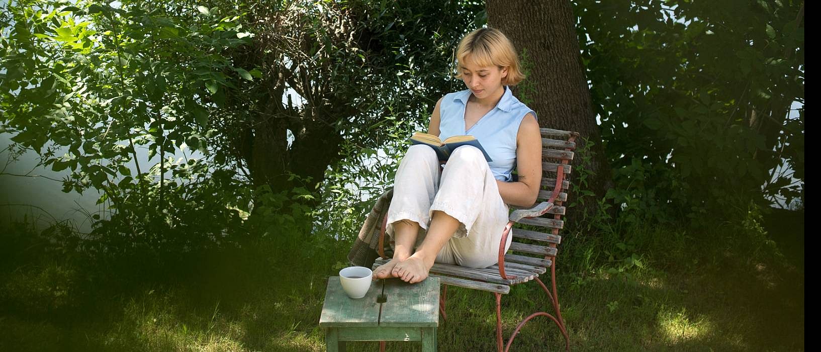 Frau sitzt entspannt im Garten