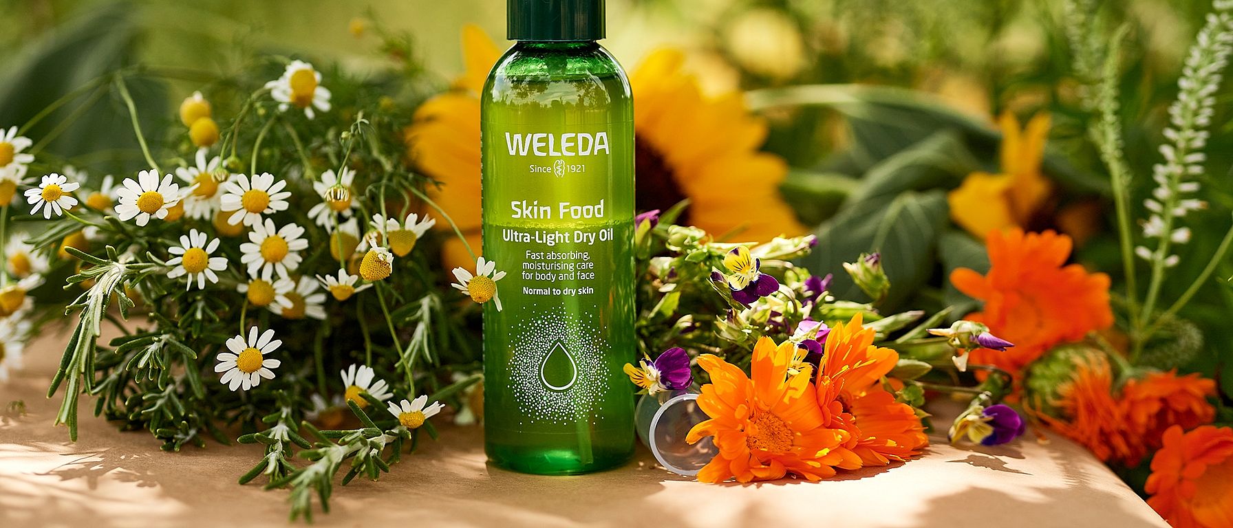 Skin Food Ultra-Light Dry Oil umringt von Blüten