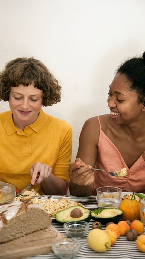 Zwei Frauen essen Früchte, Avocado, Vollkorn Brot, Haferflocken, Kerne, Nüsse