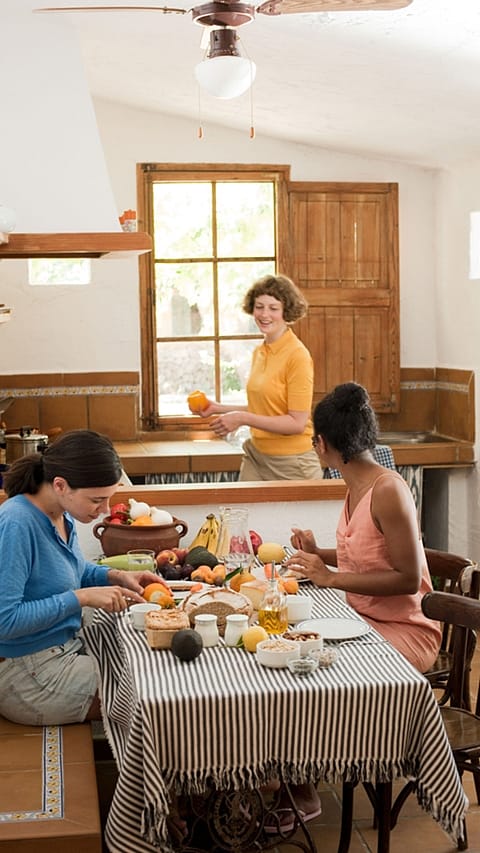Drei Frauen in einer Küche beim Essen
