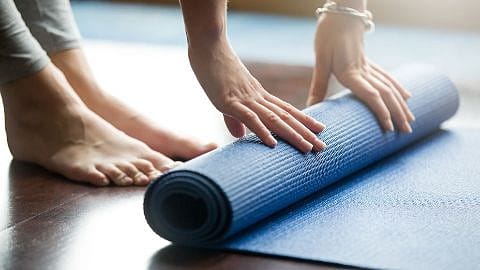 Yogamatte wird ausgerollt