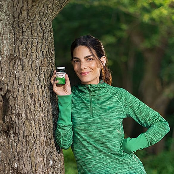 Sportliche Frau am Baum