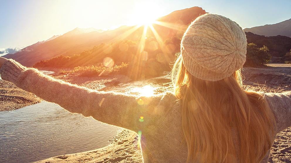 Frau entspannt in den Bergen bei Sonnenlicht