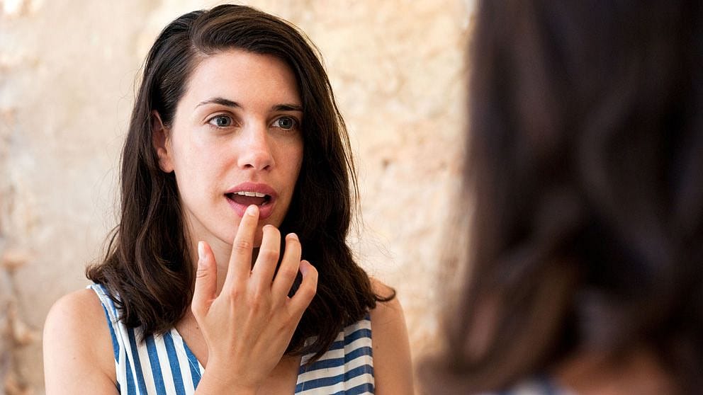 Frau cremt sich die Lippe ein